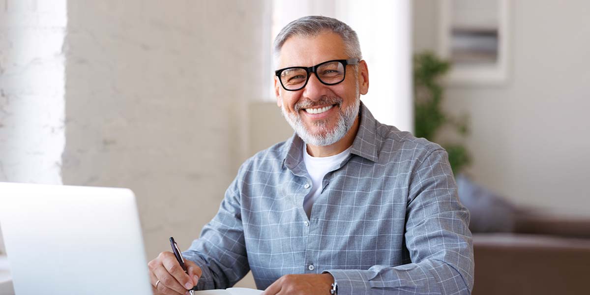 smiling man working on laptop